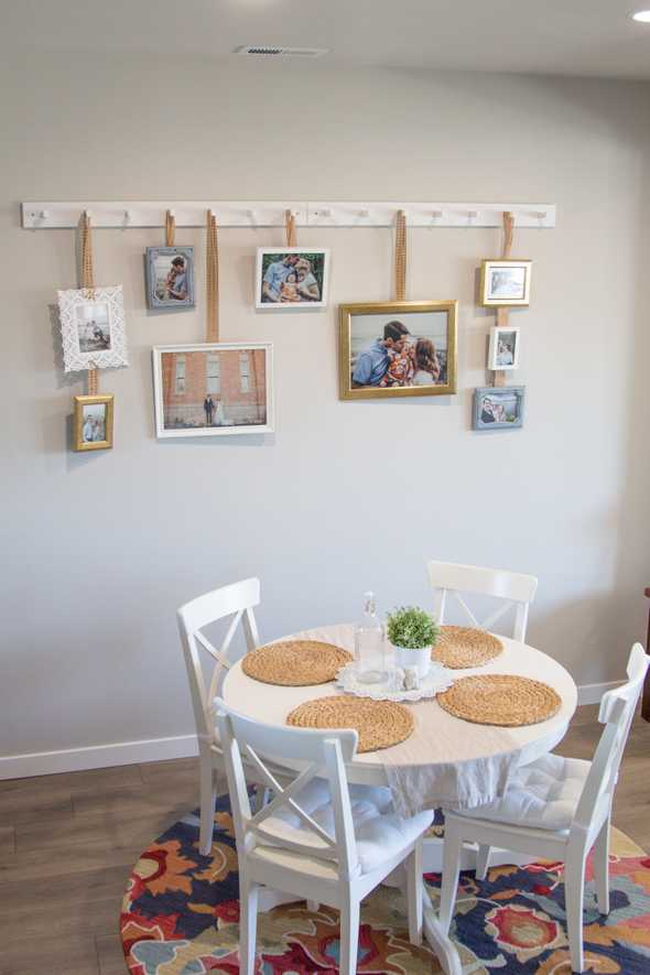 Far shot of picture frames hanging on the wall by a kitchen table