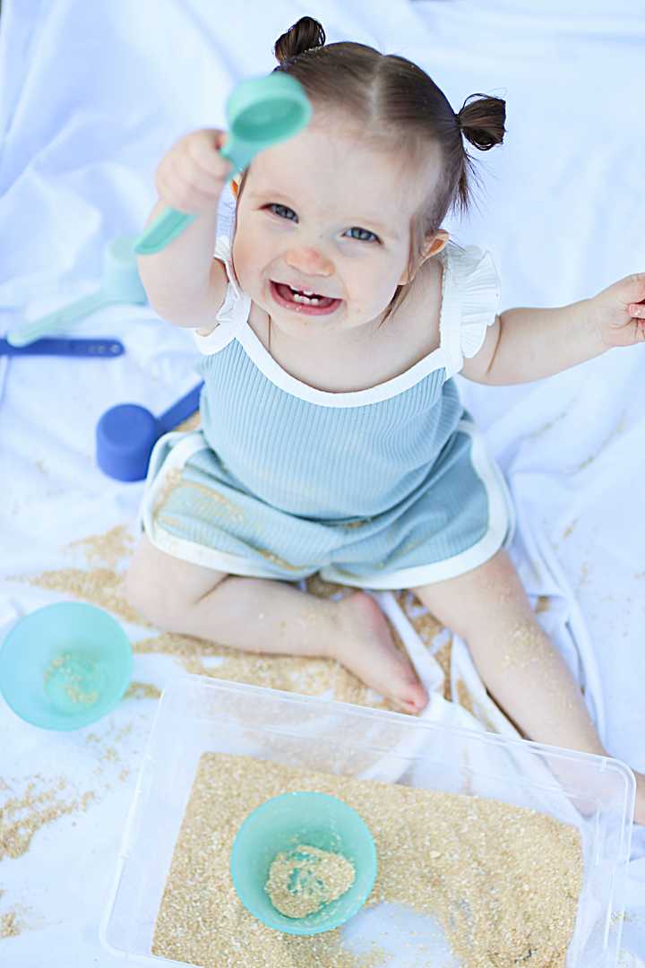 smiling toddler playing in edible sand
