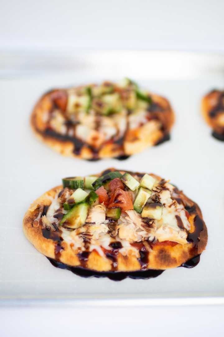 two raspberry balsamic bruschetta pizzas on a baking sheet