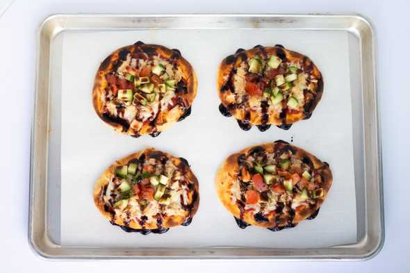 four raspberry balsamic bruschetta pizzas on a baking sheet